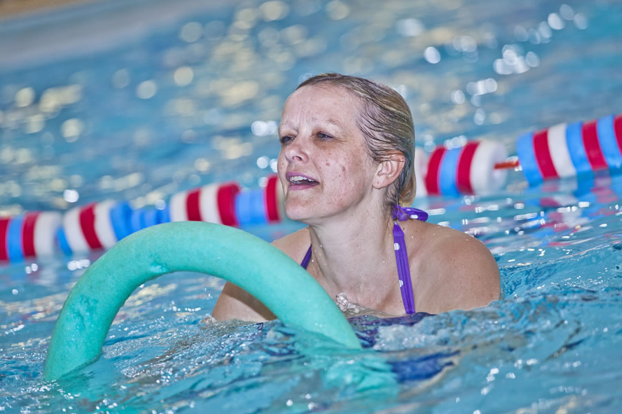 Group Of Adults Taking Part In An Aqua Aerobics Fitness Class