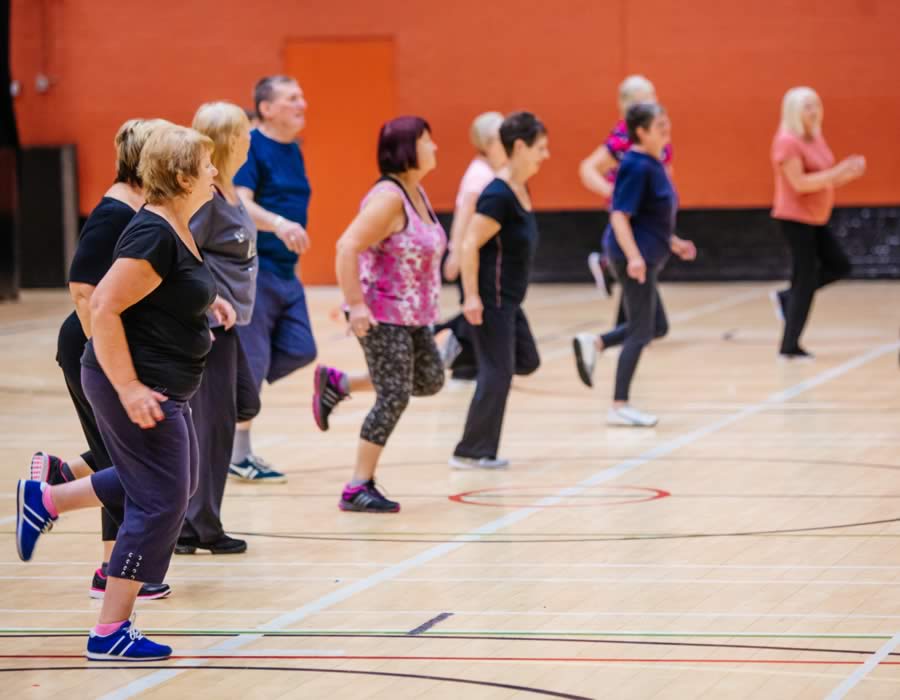 Group Of Adults Taking Part In A Fitness Class
